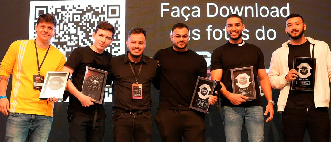 Grupo de premiados no palco do evento segurando as placas